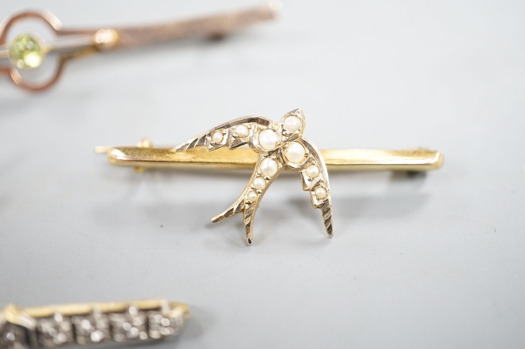 Three assorted 9ct and gem set bar brooches, including a swallow brooch, gross 5.9 grams and one other yellow metal and diamond chip set bar brooch, gross 1.7 grams.